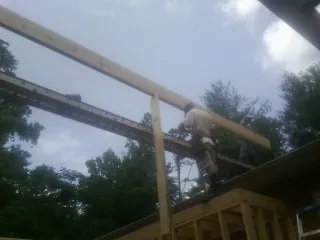 Carpenter setting a ridge beam over a new addition frame — Ice Dam Removal by Roofing Brothers in Accord