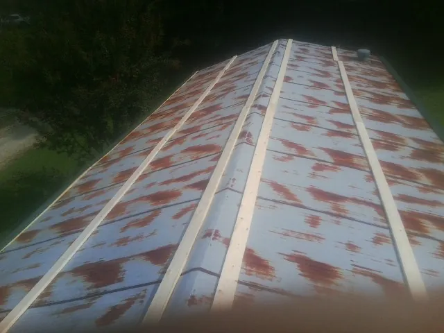 Rusted metal roof panels with new wood purlins before replacement — Storm Damage Roof Repair in Accord by Roofing Brothers