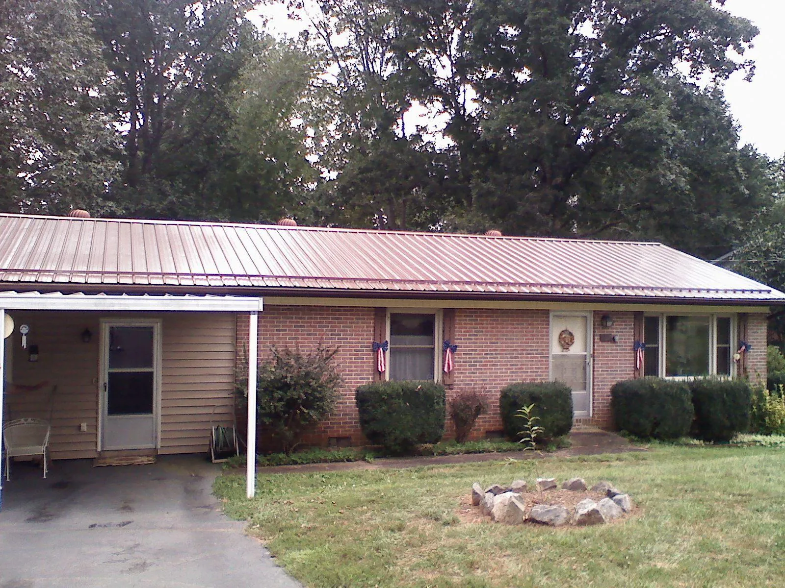 Bronze metal roof and carport on a brick ranch home — Roof Repair work by our crew in Accord