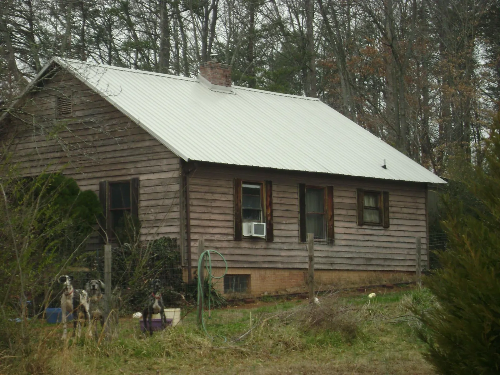 White metal roof on an old wood sided farmhouse, from a Metal Roof Installation job in Accord
